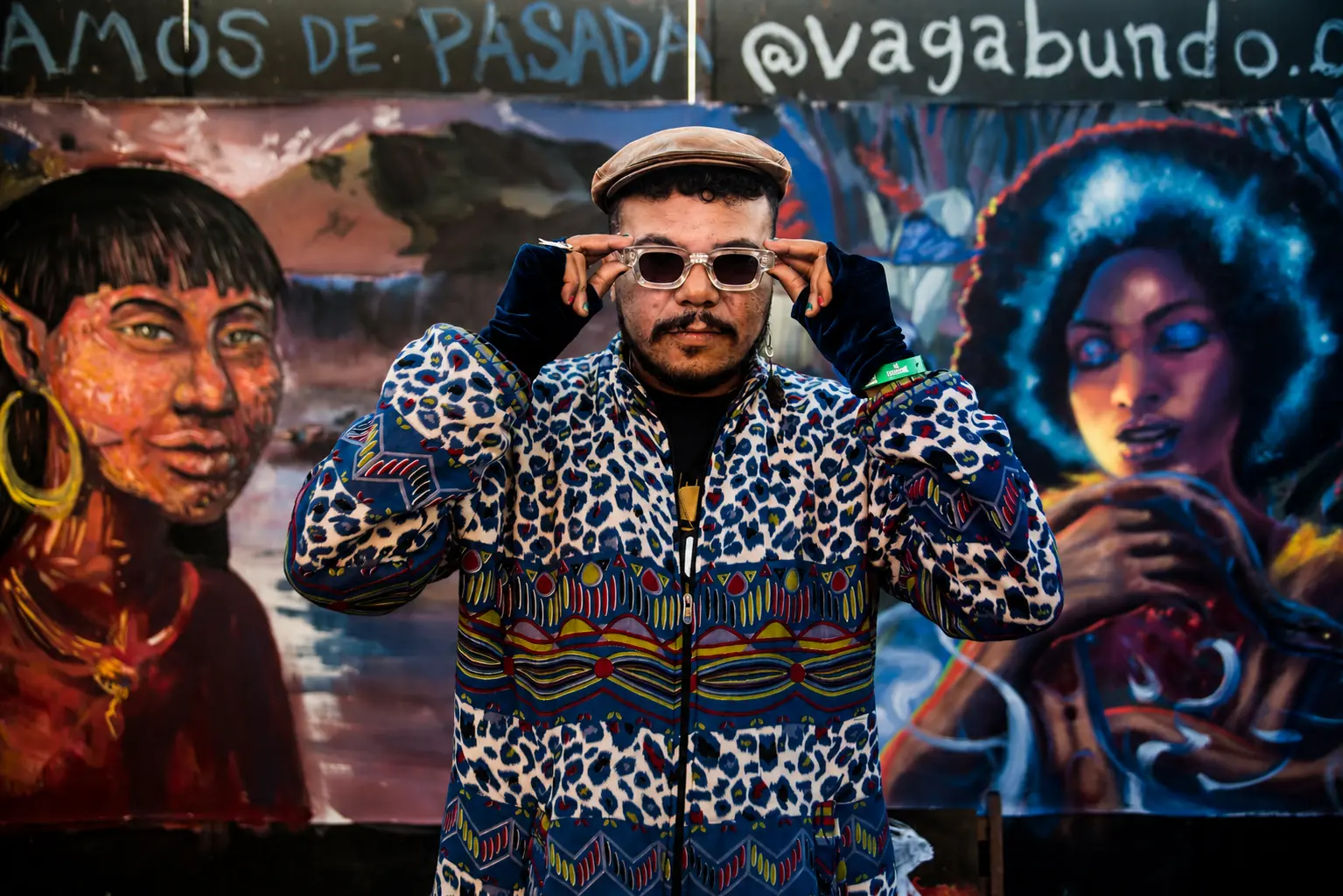 Lukote diante de um mural de arte contemporânea